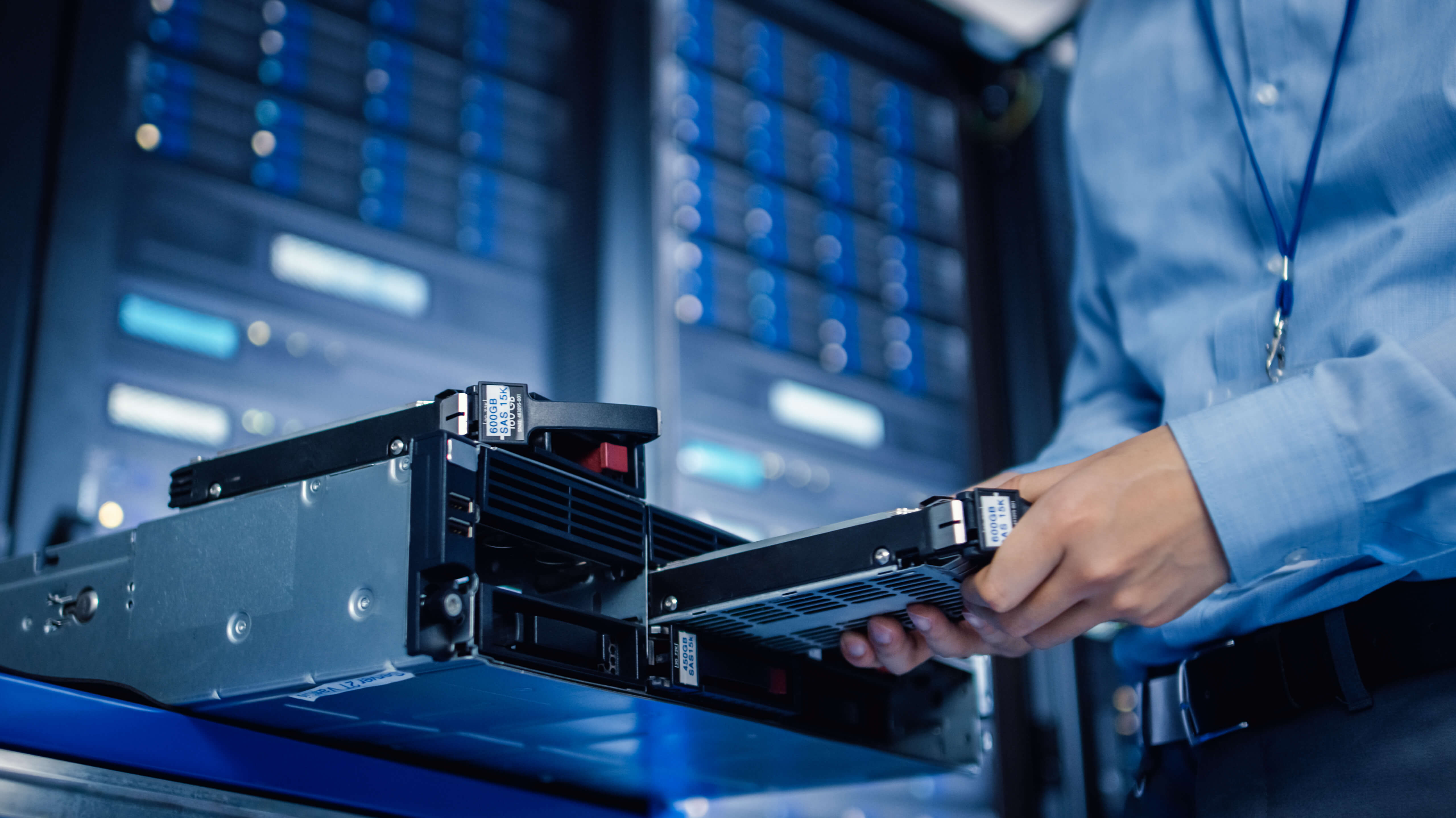 Technikerin tauscht eine Festplatte im Serverschrank